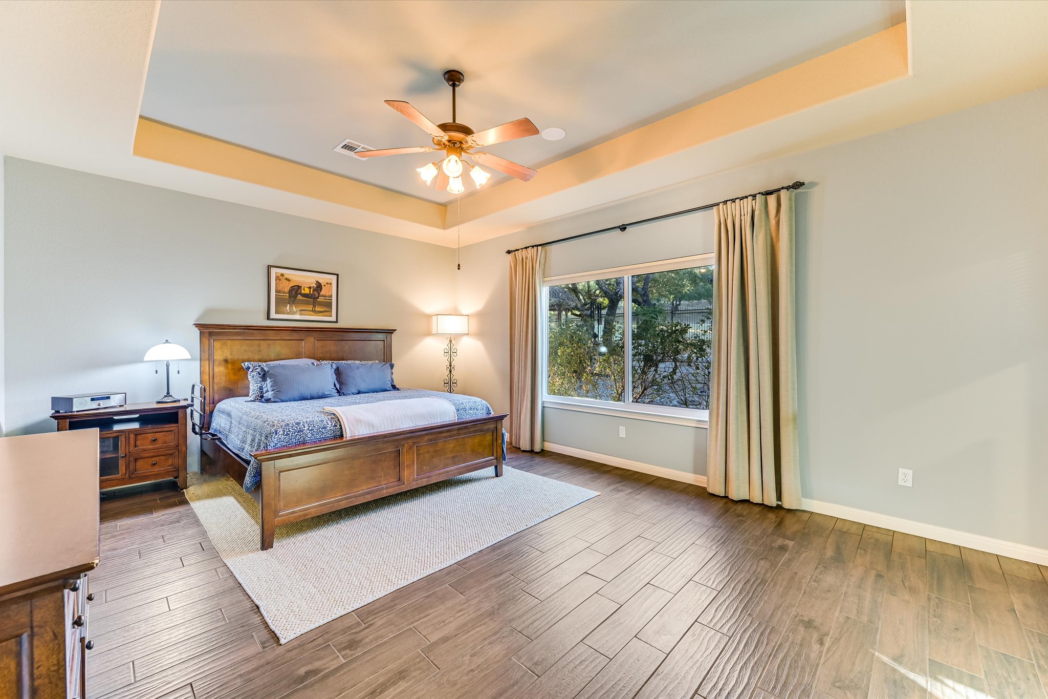 786 Ranchers Club Lane Driftwood, TX 78619 - Photo 16 of 33 Bedroom featuring a raised ceiling, wood finished floors, and ceiling fan