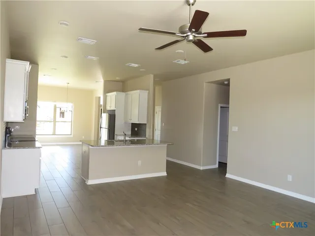 a view of a kitchen with a sink and wooden floor