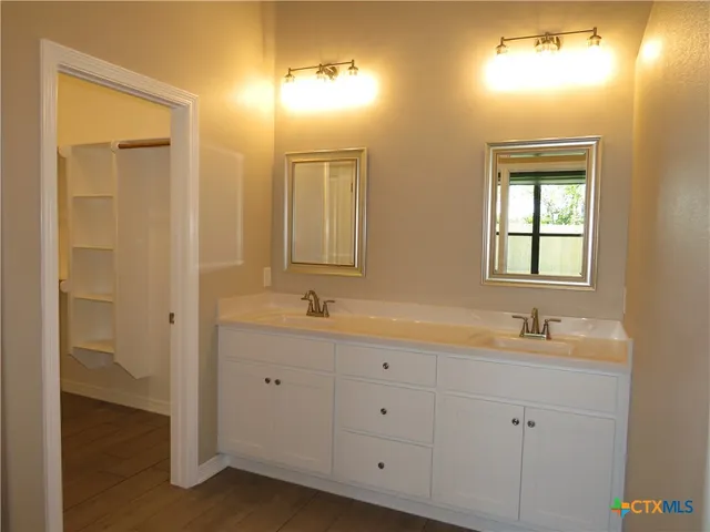 a bathroom with a double vanity sink and a mirror