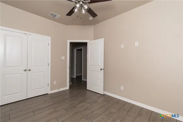 a view of an empty room with wooden floor