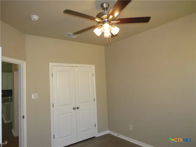 an empty room with a window and a fan