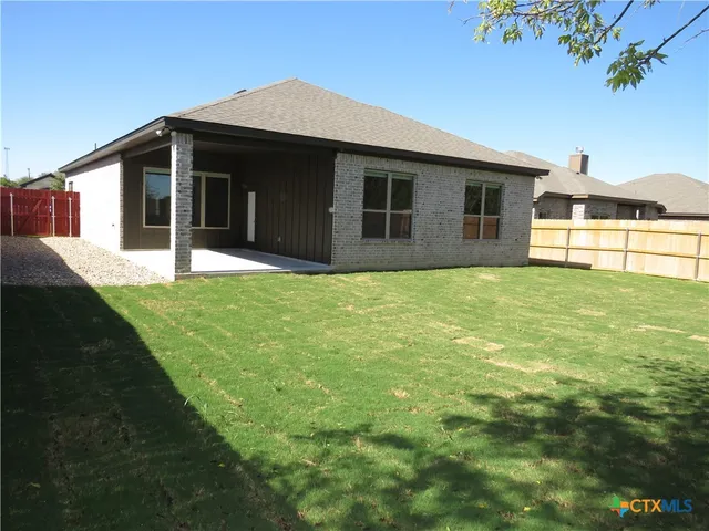 a view of garden with wooden fence
