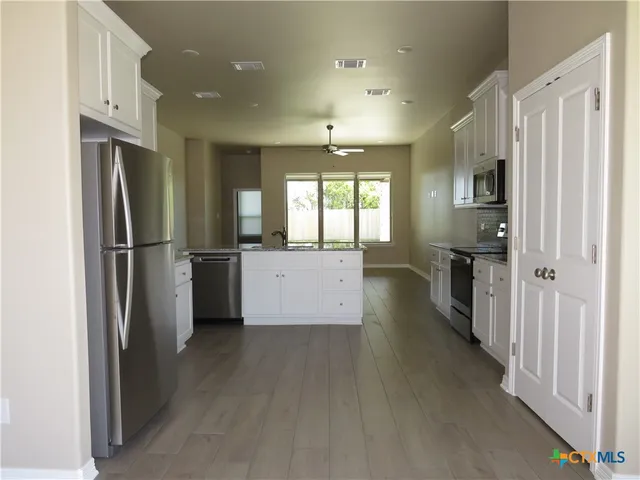 a kitchen with stainless steel appliances a refrigerator and a stove top oven