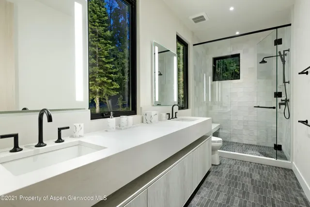 a bathroom with a double vanity sink mirror and shower