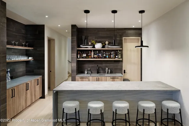 a kitchen with stainless steel appliances granite countertop a table chairs and a refrigerator