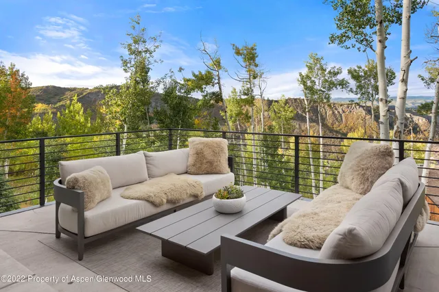 a view of a roof deck with couches and sky view