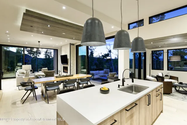 a kitchen with a table chairs and a view of living room