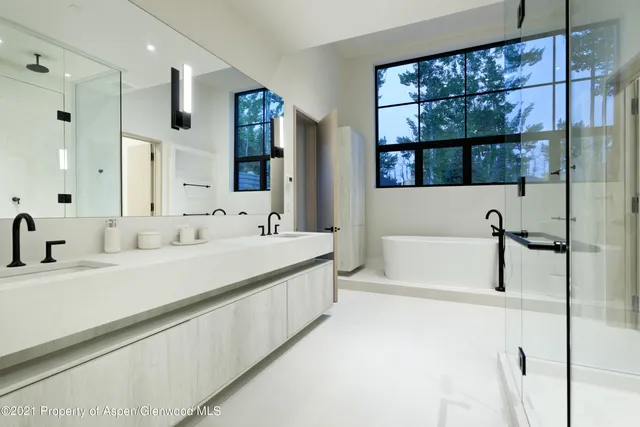a bathroom with a large tub sink and double vanity