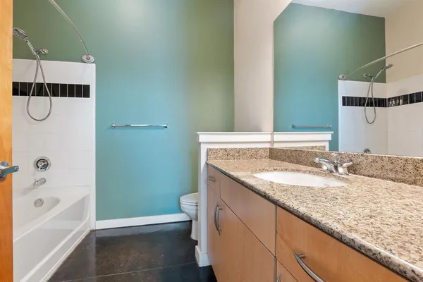 a bathroom with a granite countertop sink and a mirror