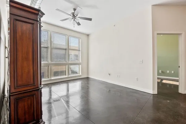 an empty room with a window and a ceiling fan