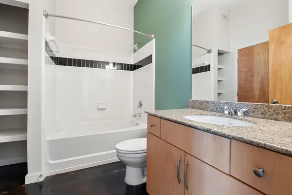 a bathroom with a granite countertop sink toilet and shower
