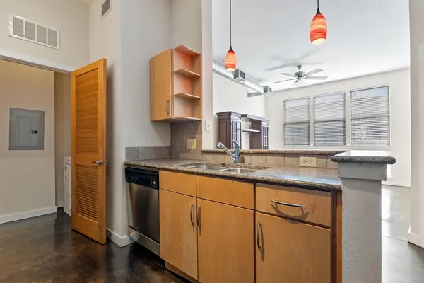 a kitchen with stainless steel appliances granite countertop a sink and wooden cabinets