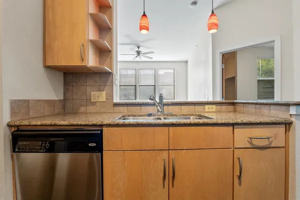 a kitchen with granite countertop a sink and a stove