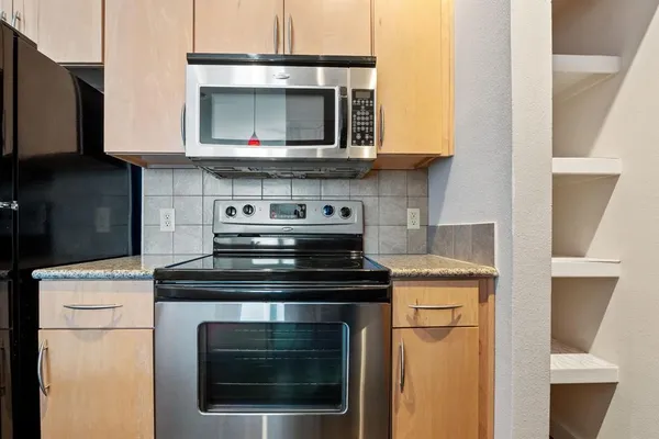 a kitchen with stainless steel appliances granite countertop a stove microwave and oven