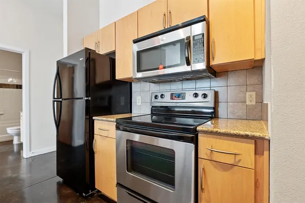 a kitchen with stainless steel appliances a stove microwave and refrigerator