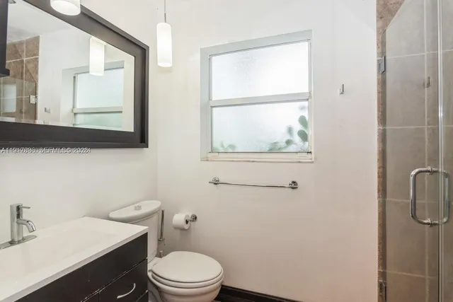 a bathroom with a toilet a sink a vanity and mirror