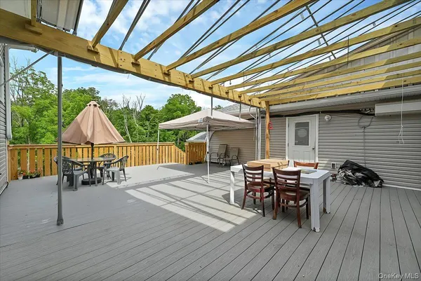 a view of a patio with table and chairs a barbeque with wooden floor and fence