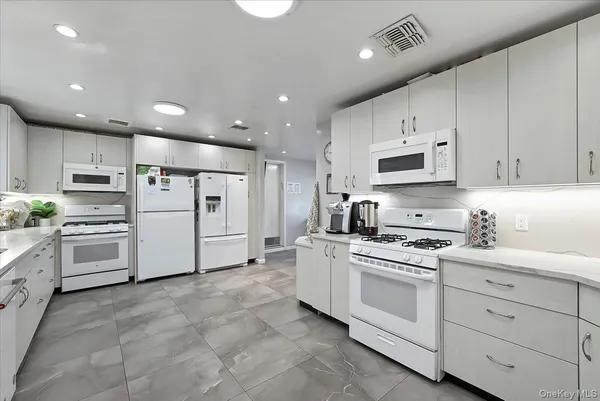 a spacious bedroom with a bed and a chandelier