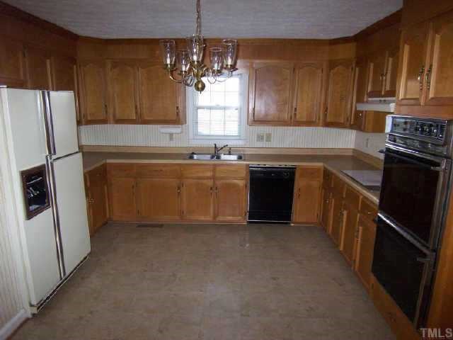 5909 Lake Elton Road Durham, NC 27713 - Photo 4 of 9 Large country kitchen has double oven, smooth top range, side-by-side refrigerator, counter top microwave. Everything you need and plenty of space for multiple cooks.