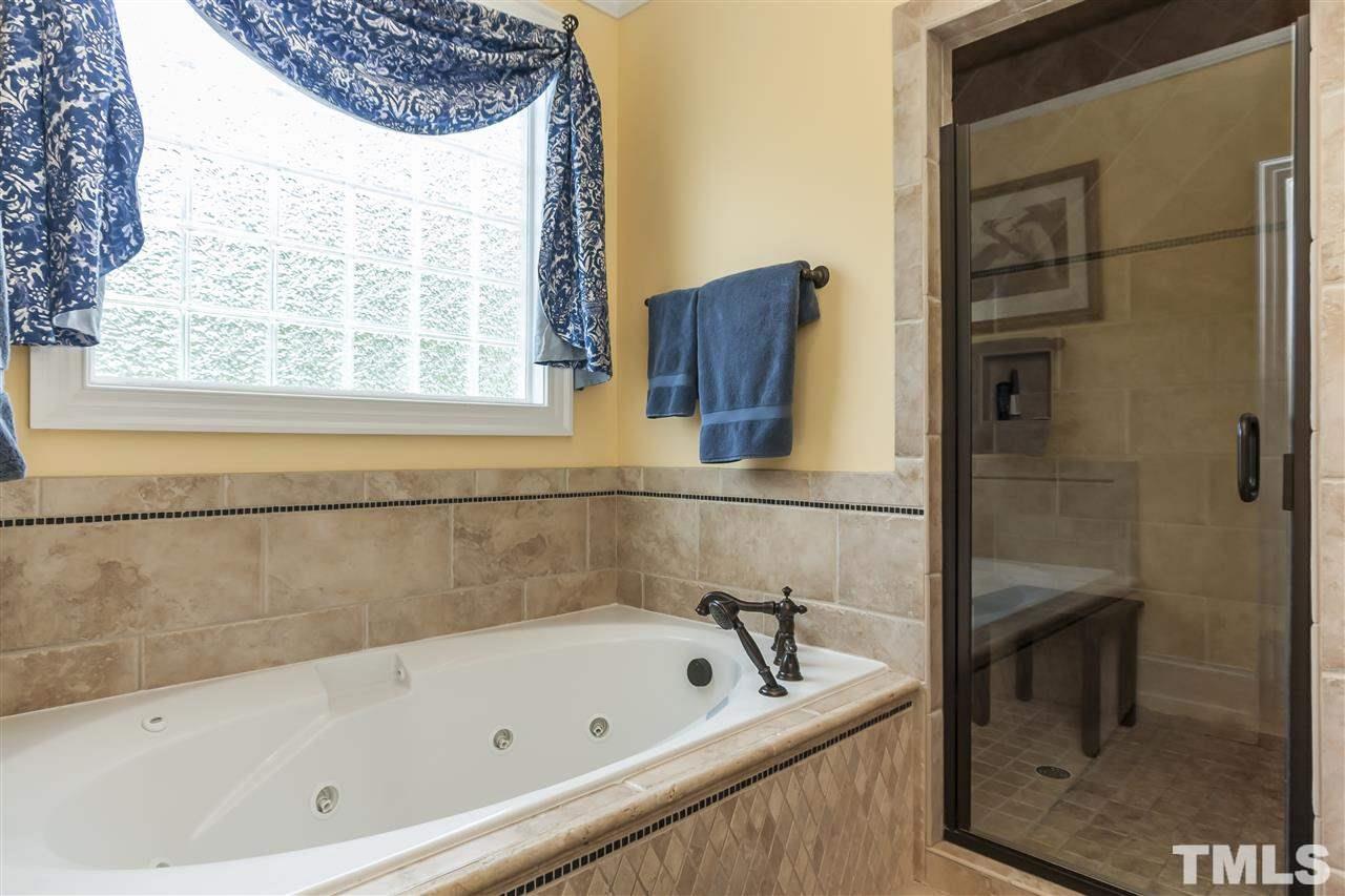 2933 Claremont Road Raleigh, NC 27608 - Photo 17 of 25 a bathroom with a tub a sink and a window