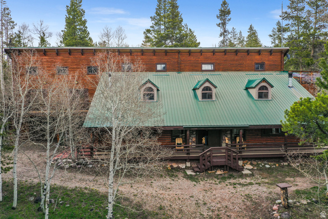 4725 Pine Ridge Road Evanston, UT 82930 - Photo 79 of 82 Log-style exterior with a green metal roof and multiple dormer windows