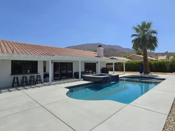 a view of a house with swimming pool and sitting area
