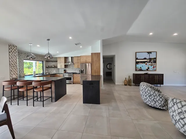 a view of a dining room with furniture a chandelier and wooden floor