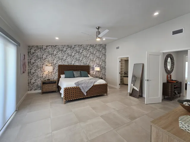 a front view of a house with a yard and potted plants