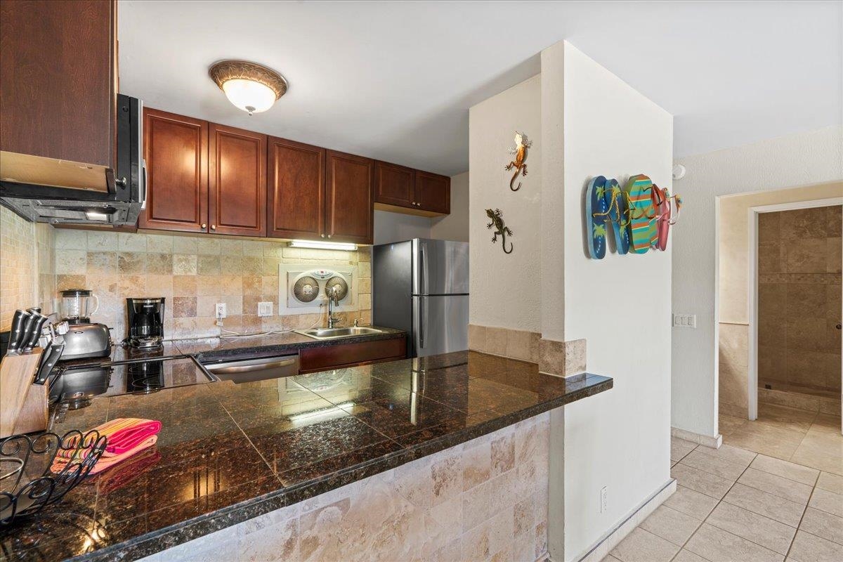 4909 Lower Honoapiilani Road, Unit E2E Lahaina, HI 96761 - Photo 11 of 42 a kitchen with granite countertop a refrigerator and a sink