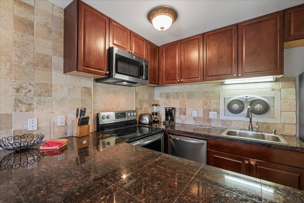 4909 Lower Honoapiilani Road, Unit E2E Lahaina, HI 96761 - Photo 12 of 42 a kitchen with stainless steel appliances granite countertop a sink stove and cabinets
