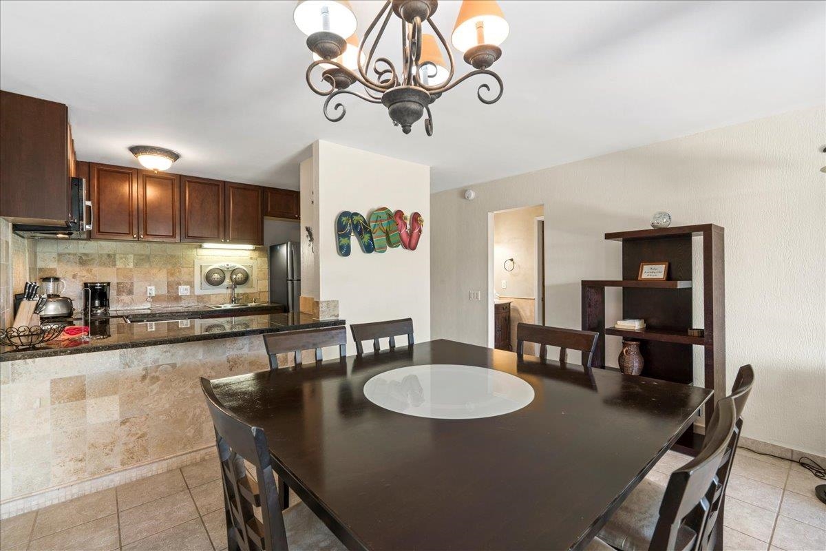4909 Lower Honoapiilani Road, Unit E2E Lahaina, HI 96761 - Photo 17 of 42 a kitchen with a dining table chairs and microwave