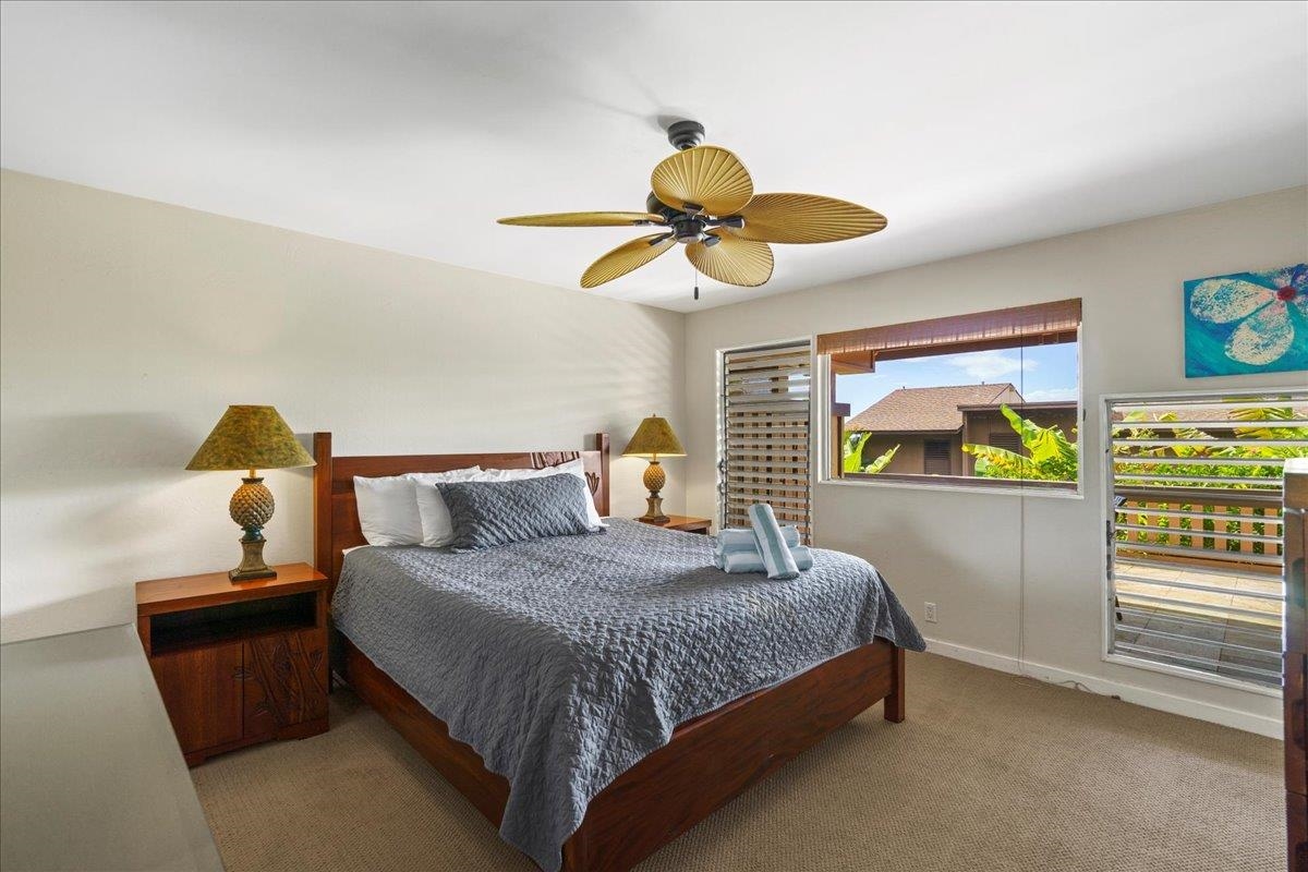 4909 Lower Honoapiilani Road, Unit E2E Lahaina, HI 96761 - Photo 23 of 42 a bedroom with a bed and ceiling fan