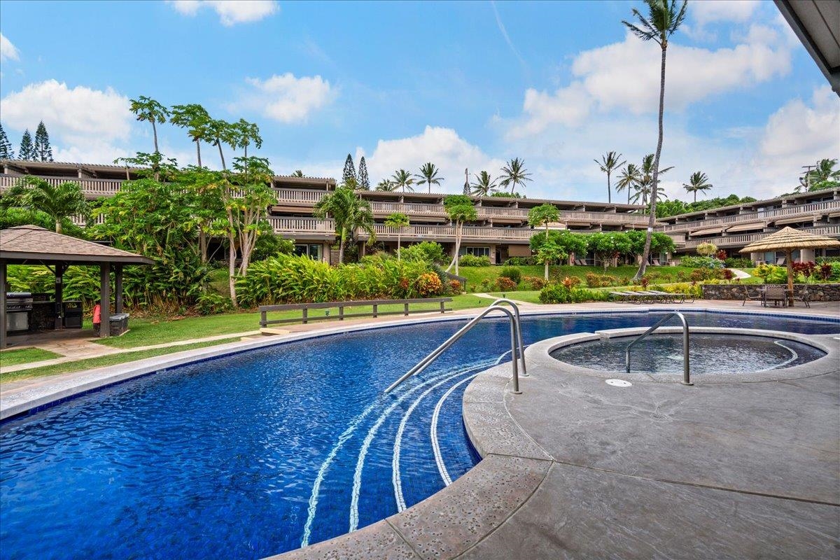 4909 Lower Honoapiilani Road, Unit E2E Lahaina, HI 96761 - Photo 31 of 42 a view of a swimming pool with a lawn chairs under an umbrella