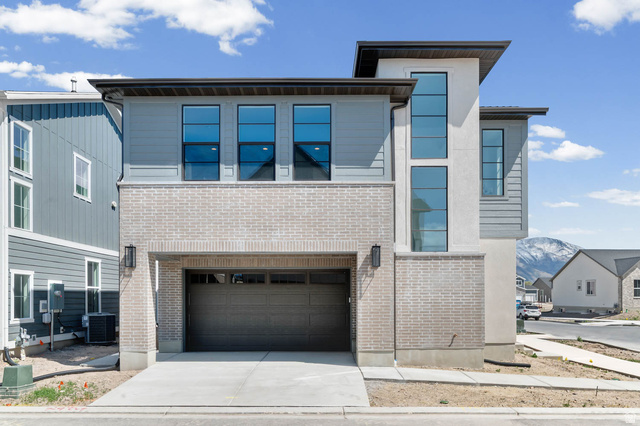 3204 West 1570 North Provo, UT 84601 - Photo 4 of 19 Contemporary house featuring a garage, concrete driveway, brick siding, and a mountain view