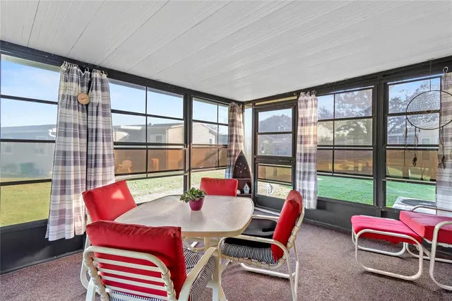 a dining room with furniture and a floor to ceiling window