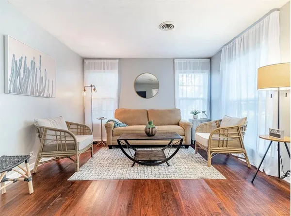 a living room with furniture and a wooden floor