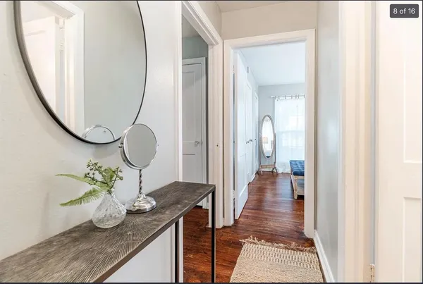 a view of a hallway with mirror and furniture