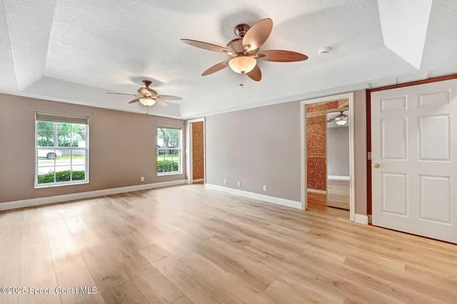 a spacious bedroom with a bed couch and a large window