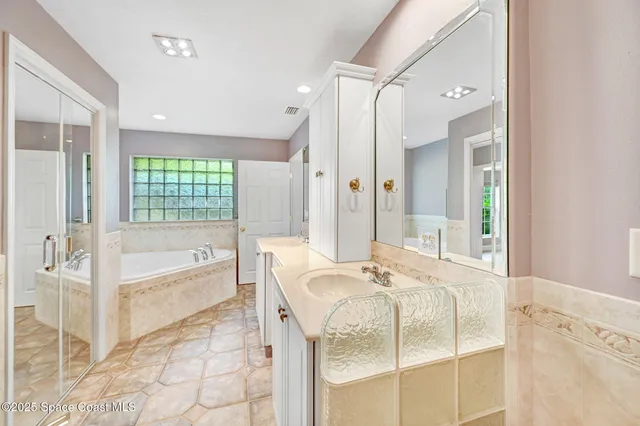 a bathroom with a tub sink and mirror