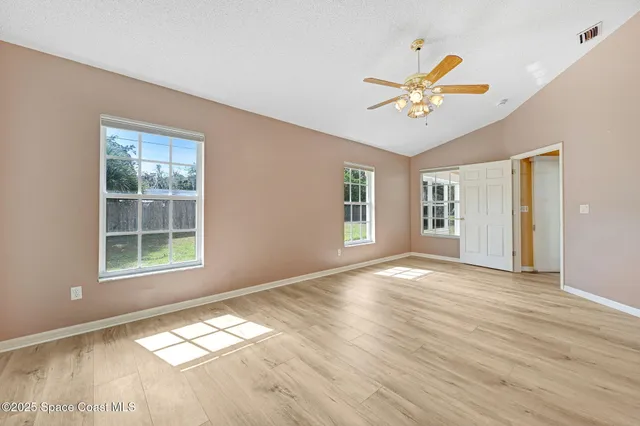 a view of empty room with wooden floor