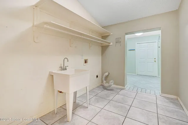 an empty room with chandelier fan and windows