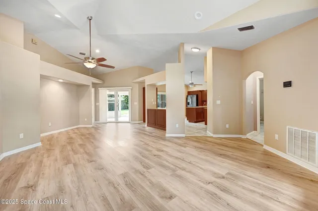 a living room with furniture kitchen view and a chandelier