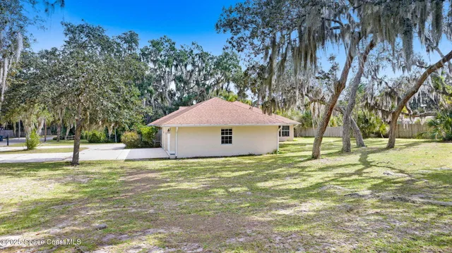 an aerial view of a residential houses with yard