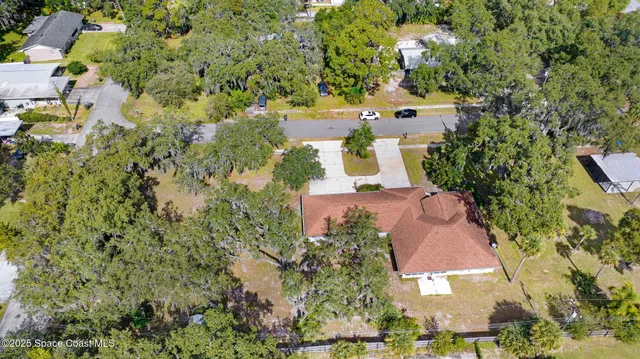an aerial view of a house with a garden and lake view
