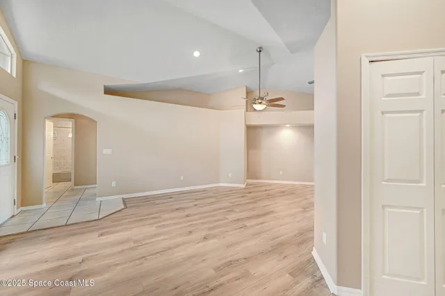 a view of an empty room and kitchen view