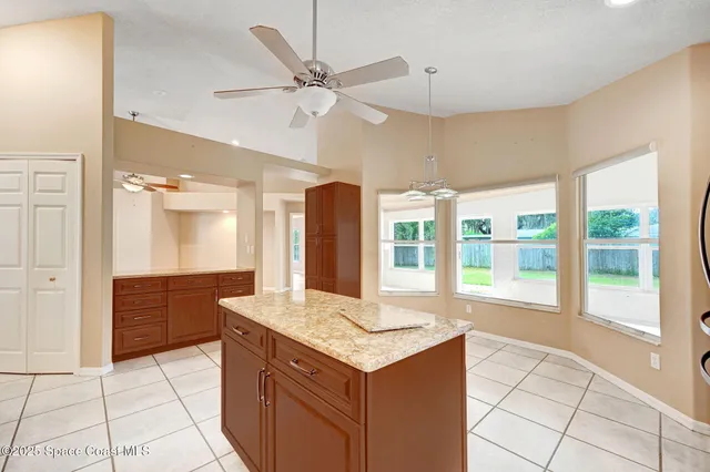 a kitchen with stainless steel appliances granite countertop a refrigerator a sink a stove top oven and a refrigerator
