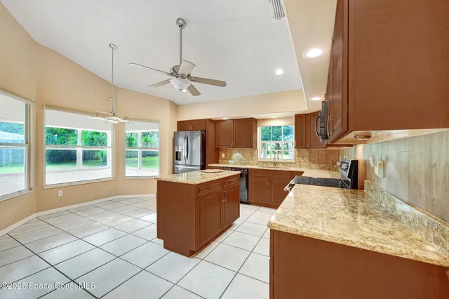 a kitchen with granite countertop a sink and a refrigerator
