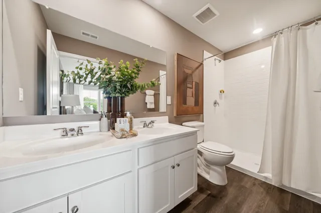 a bathroom with a toilet a sink and a large mirror