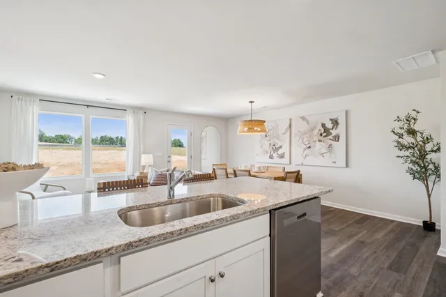 a kitchen with stainless steel appliances granite countertop a sink a stove and a wooden cabinets