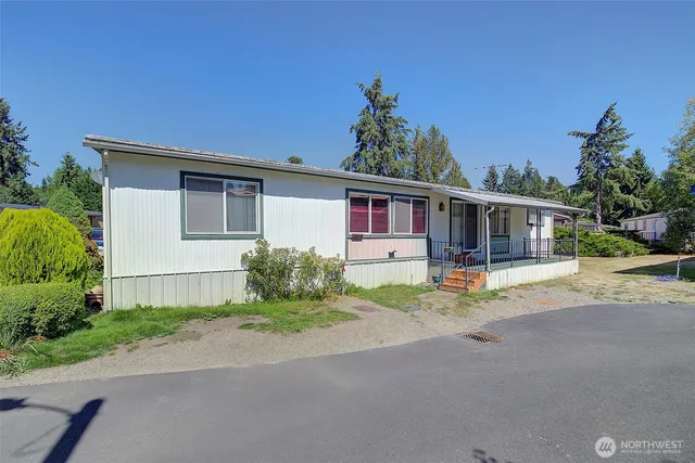 a front view of a house with a yard and potted plants